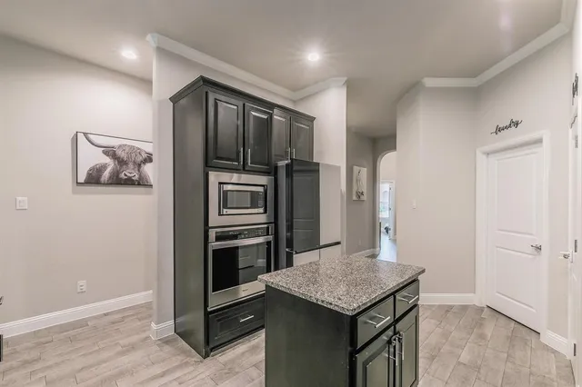 a kitchen with stainless steel appliances granite countertop a refrigerator and a stove top oven