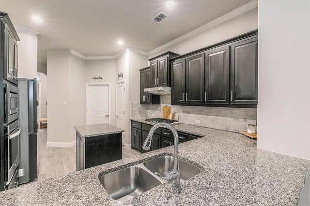 a kitchen with stainless steel appliances granite countertop a sink stove and refrigerator