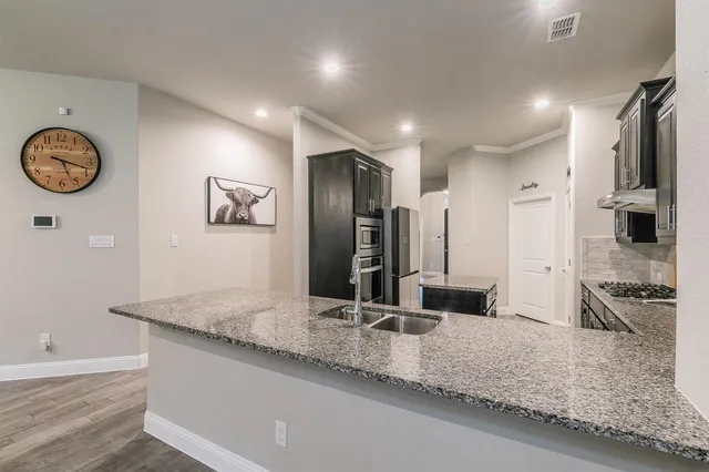a bathroom with a granite countertop sink and a large mirror