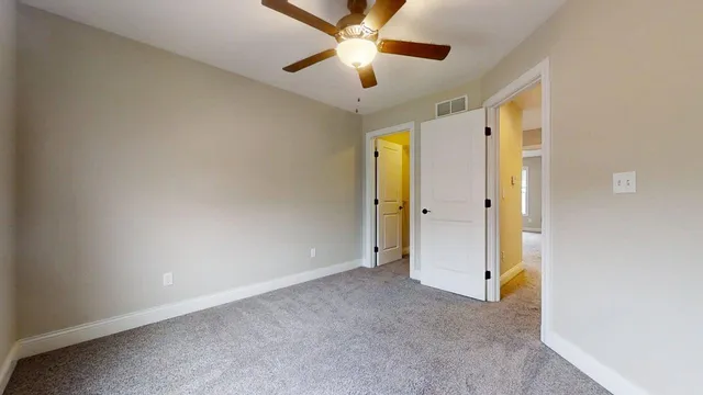a view of empty room with window and ceiling fan