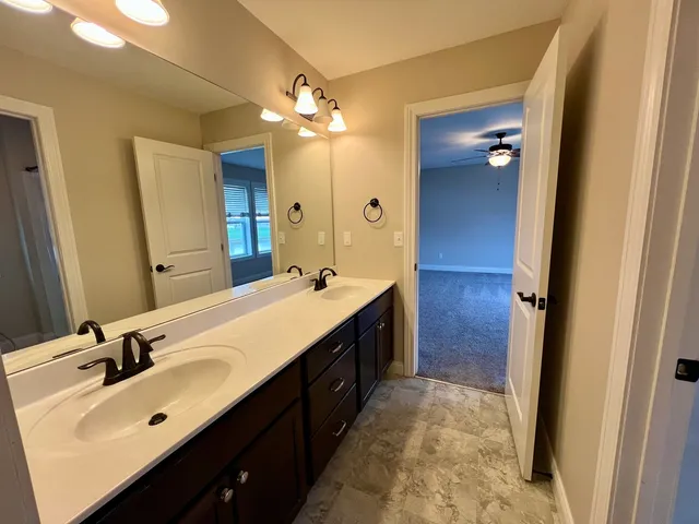 a bathroom with a double vanity sink mirror and toilet