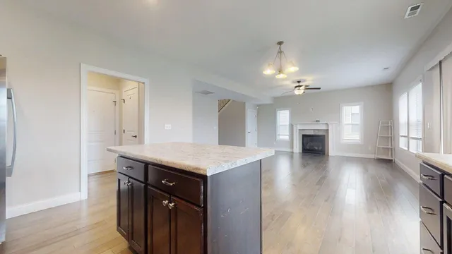 a kitchen with granite countertop a stove cabinets and wooden floor