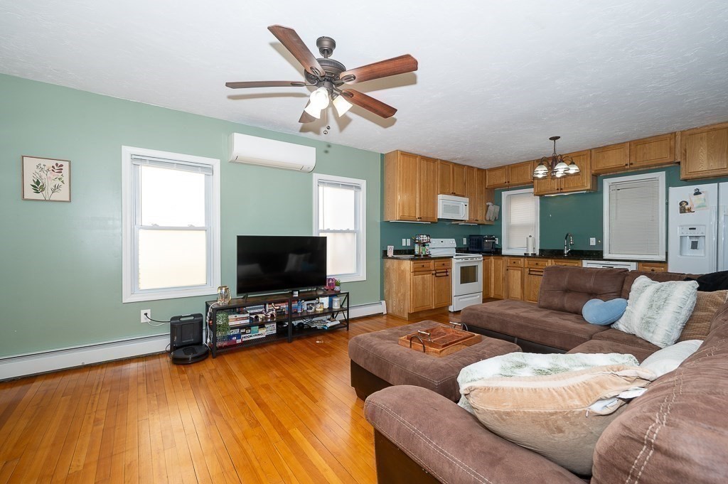 134 Baker Street Gardner, MA 01440 - Photo 27 of 42 a living room with furniture and a flat screen tv with kitchen view