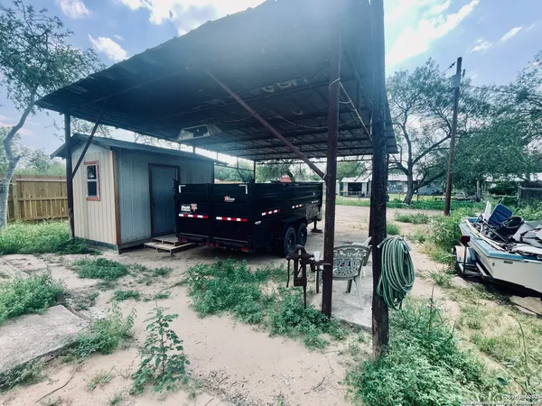 a view of a patio with table and chairs under an umbrella with a big yard