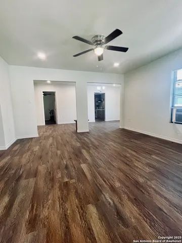 a view of a livingroom with a ceiling fan and wooden floor