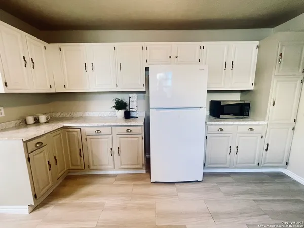 a kitchen with cabinets and white appliances