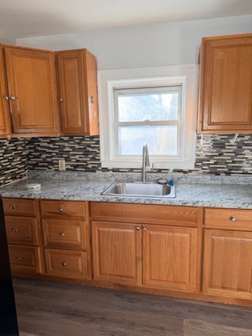 2 West 10th Street, Unit 2 Lowell, MA 01850 - Photo 11 of 13 a kitchen with granite countertop wooden cabinets a sink and a window