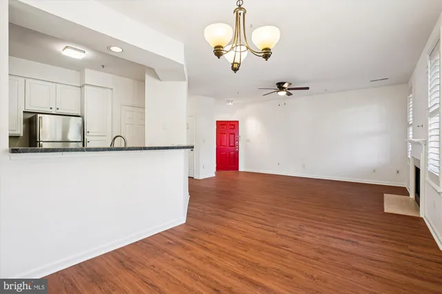 a view of a kitchen with wooden floor and a ceiling fan