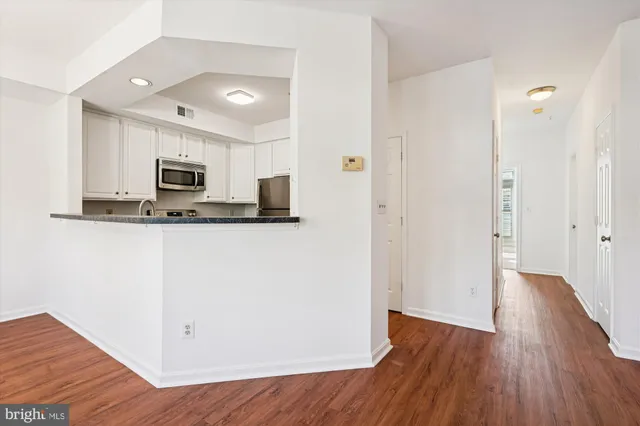 a view of kitchen with microwave and wooden floor