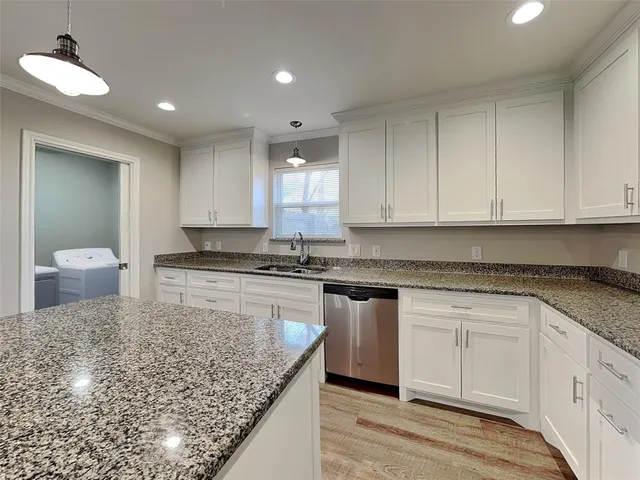 a kitchen with a sink dishwasher stove and cabinets