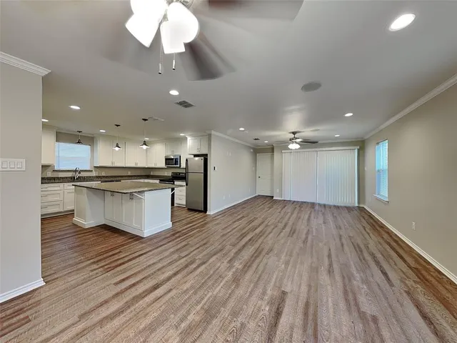 a view of kitchen with granite countertop cabinets and refrigerator