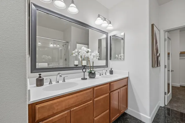 a bathroom with double vanity sinks and a mirror