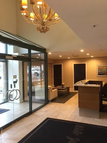 a living room with furniture a flat screen tv and floor to ceiling window