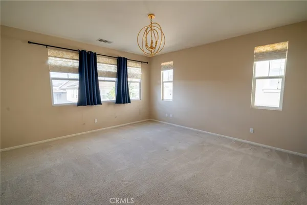 an empty room with a window and chandelier