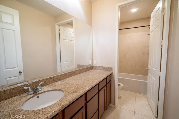 a bathroom with a granite countertop sink shower and a mirror
