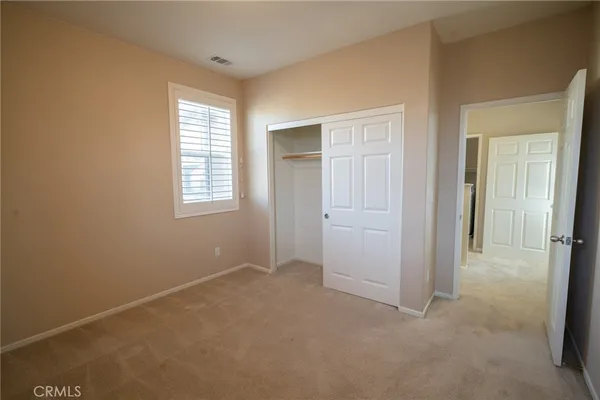an empty room with windows and closet
