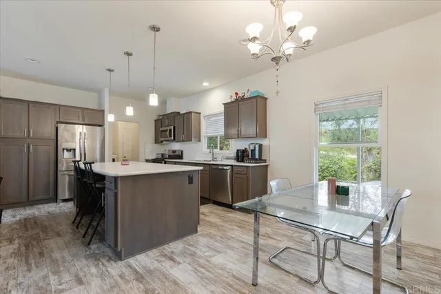 a kitchen with a table chairs refrigerator and microwave