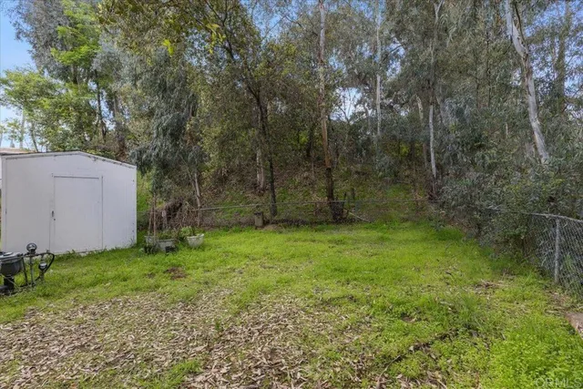 a backyard of a house with lots of plants and tree