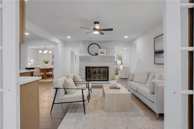 a kitchen with stainless steel appliances granite countertop a dining table chairs refrigerator and sink