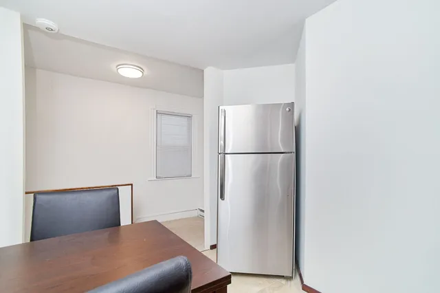 a bedroom with a bed and a refrigerator