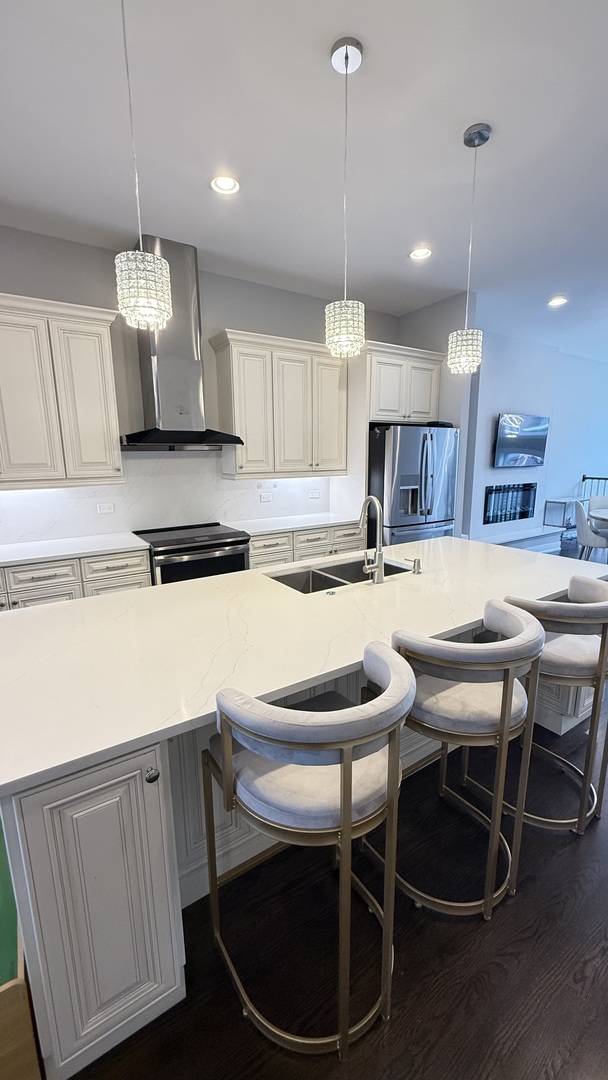 3422 South Normal Avenue Chicago, IL 60616 - Photo 18 of 48 a kitchen with a dining table chairs stainless steel appliances and cabinets