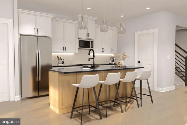 a kitchen with stainless steel appliances kitchen island granite countertop a table chairs refrigerator and microwave