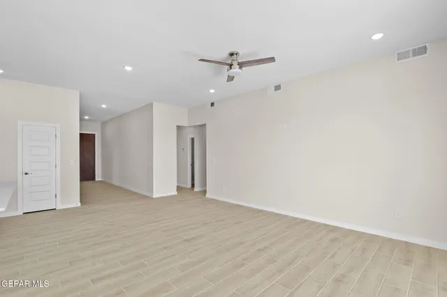 a view of an empty room with a ceiling fan