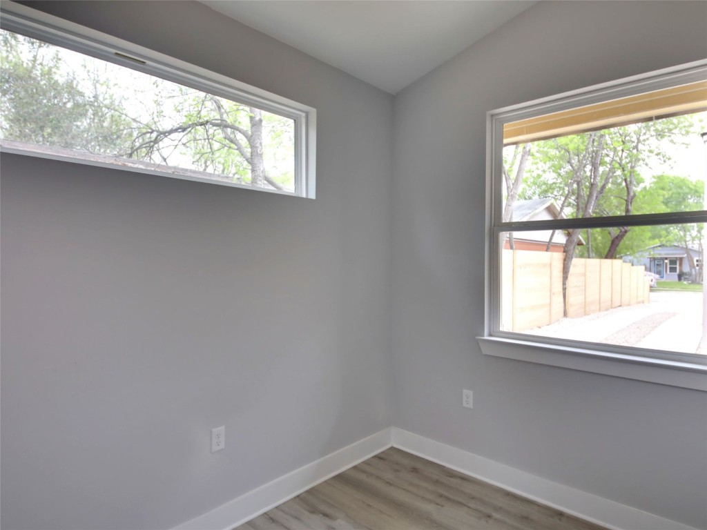 6111 Carnation Terrace, Unit 2 Austin, TX 78741 - Photo 15 of 34 Unfurnished room with plenty of natural light, light wood finished floors, and lofted ceiling