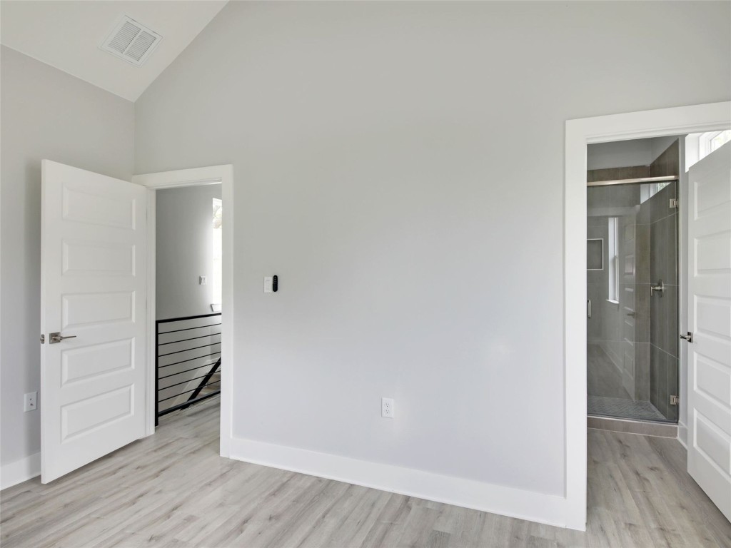 6111 Carnation Terrace, Unit 2 Austin, TX 78741 - Photo 19 of 34 Empty room with light wood-style flooring and vaulted ceiling