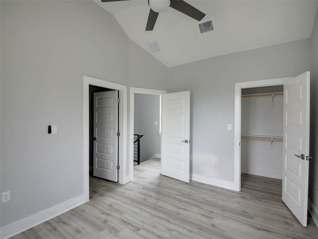 6111 Carnation Terrace, Unit 2 Austin, TX 78741 - Photo 20 of 34 Unfurnished bedroom with a walk in closet, light wood finished floors, a ceiling fan, and high vaulted ceiling