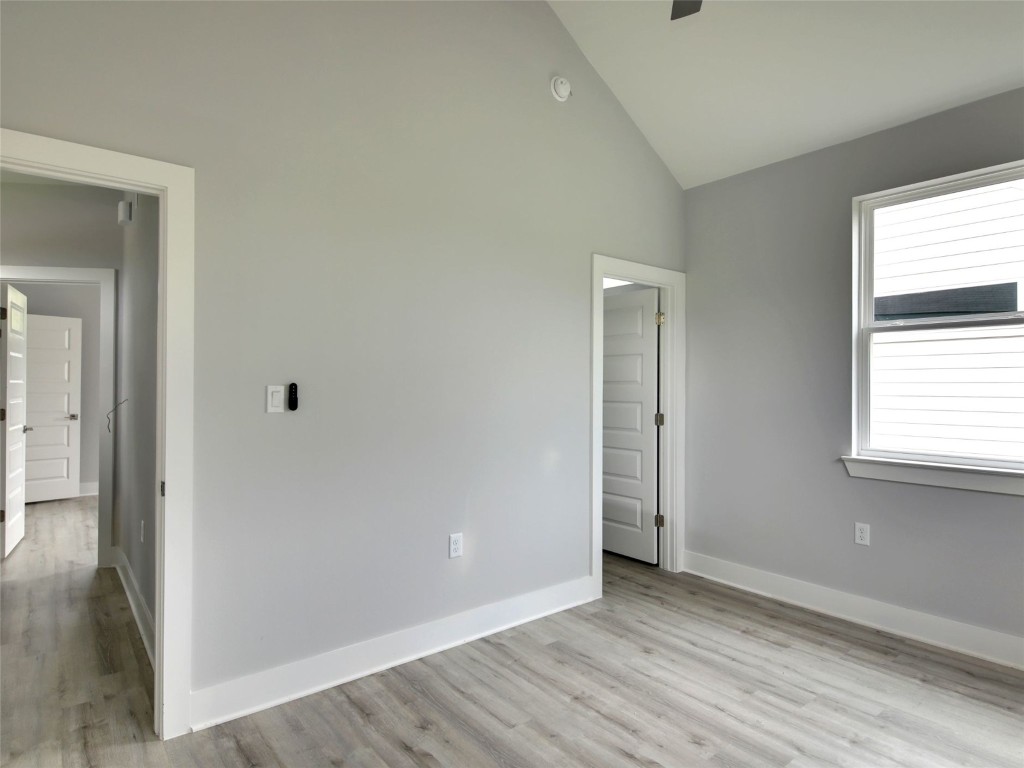 6111 Carnation Terrace, Unit 2 Austin, TX 78741 - Photo 21 of 34 Unfurnished bedroom featuring light wood finished floors, a ceiling fan, and high vaulted ceiling