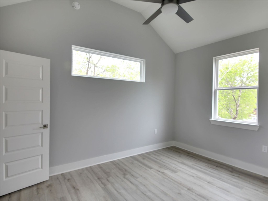 6111 Carnation Terrace, Unit 2 Austin, TX 78741 - Photo 25 of 34 Unfurnished room featuring vaulted ceiling, plenty of natural light, light wood-type flooring, and a ceiling fan