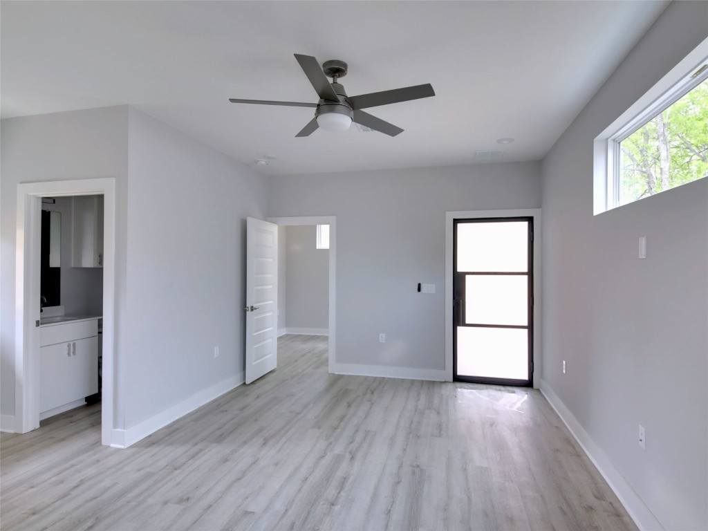6111 Carnation Terrace, Unit 2 Austin, TX 78741 - Photo 4 of 34 Unfurnished bedroom with a ceiling fan, light wood-style floors, and connected bathroom