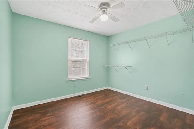 an empty room with a window and wooden floor