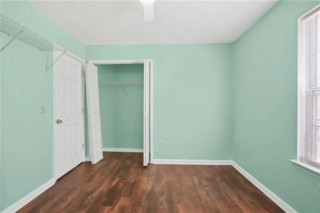 an empty room with wooden floor and closet