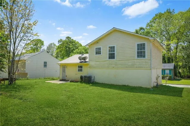 a view of a backyard with plants and large tree