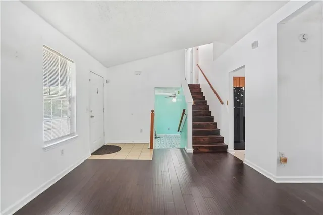 a view of an entryway with wooden floor and stairs