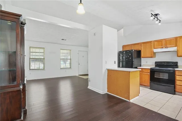 a kitchen with granite countertop wooden floors and stainless steel appliances