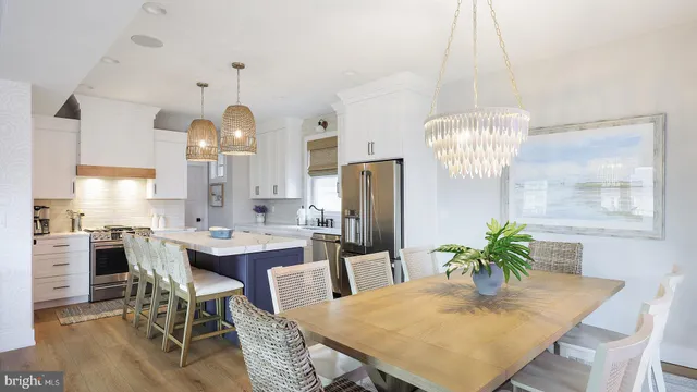 a dining room with furniture a chandelier and kitchen view