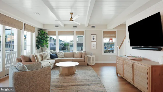 a living room with furniture a flat screen tv and a floor to ceiling window