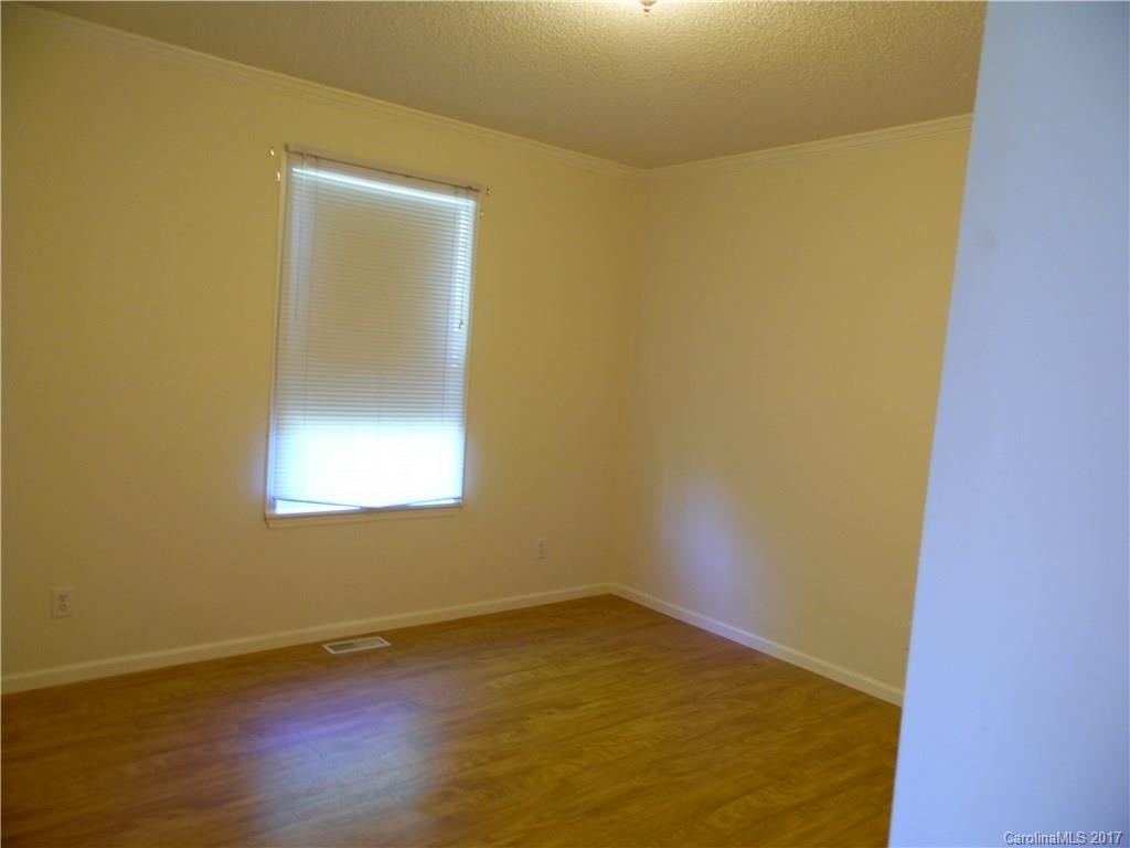 4184 State Rd S-29-304, Unit 2 Lancaster, SC 29720 - Photo 10 of 14 an empty room with a wooden floor and a window