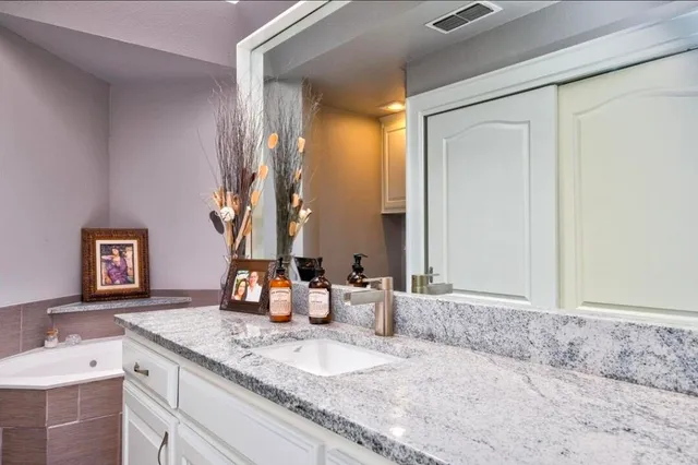 a bathroom with a granite countertop sink and a mirror