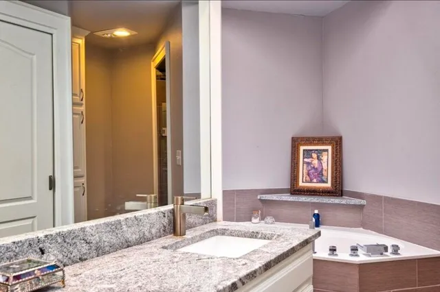 a bathroom with a granite countertop sink and a mirror