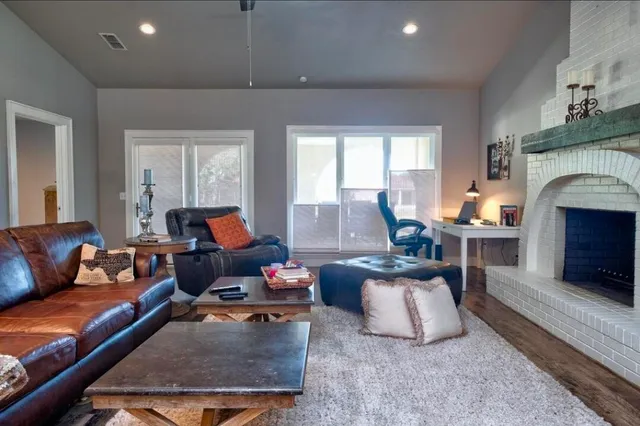 a living room with furniture a fireplace and a large window