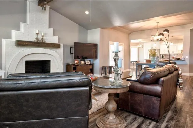 a living room with furniture a fireplace and a flat screen tv