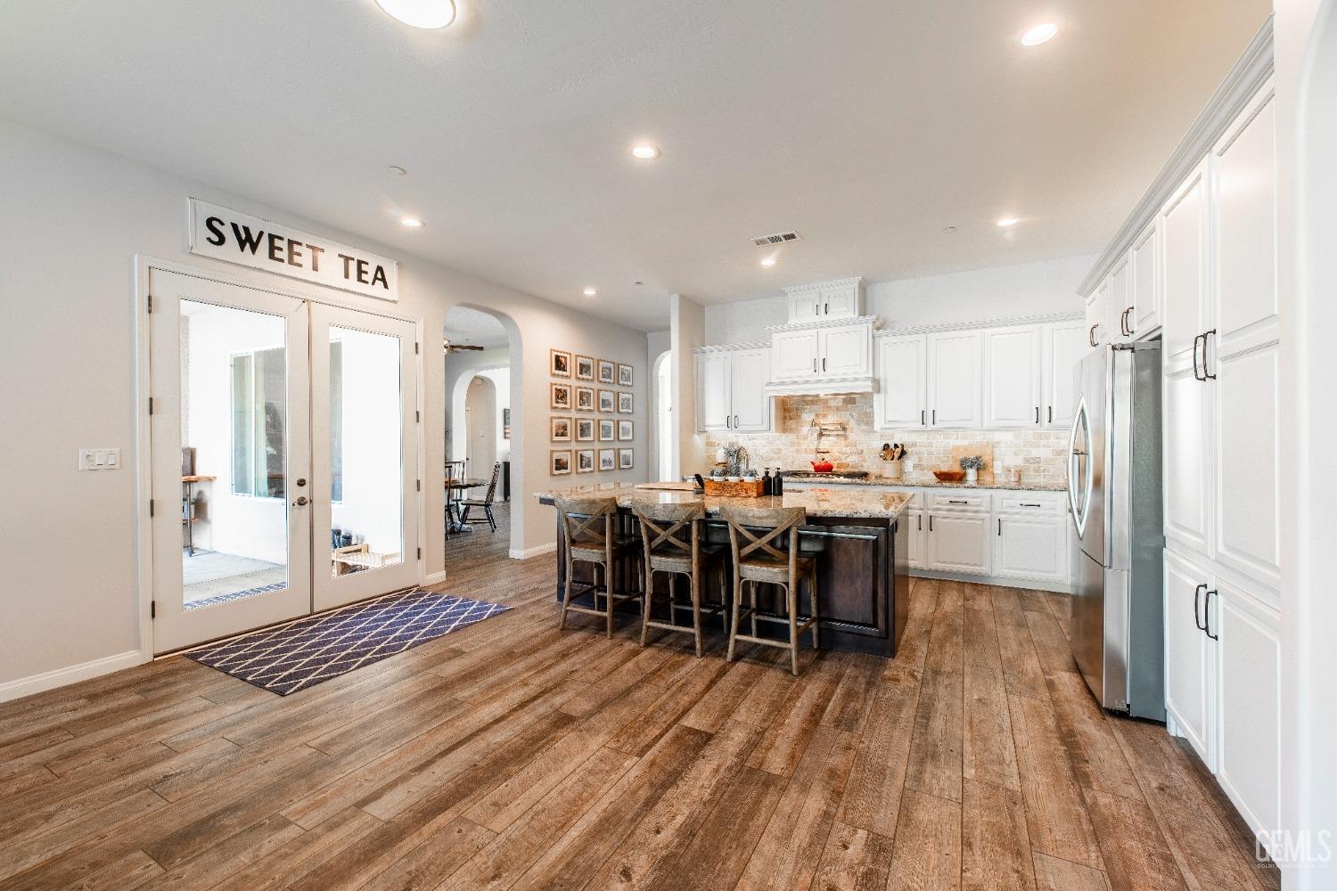 Undisclosed Address Bakersfield, CA 93312 - Photo 17 of 43 a kitchen with kitchen island wooden floors and center island