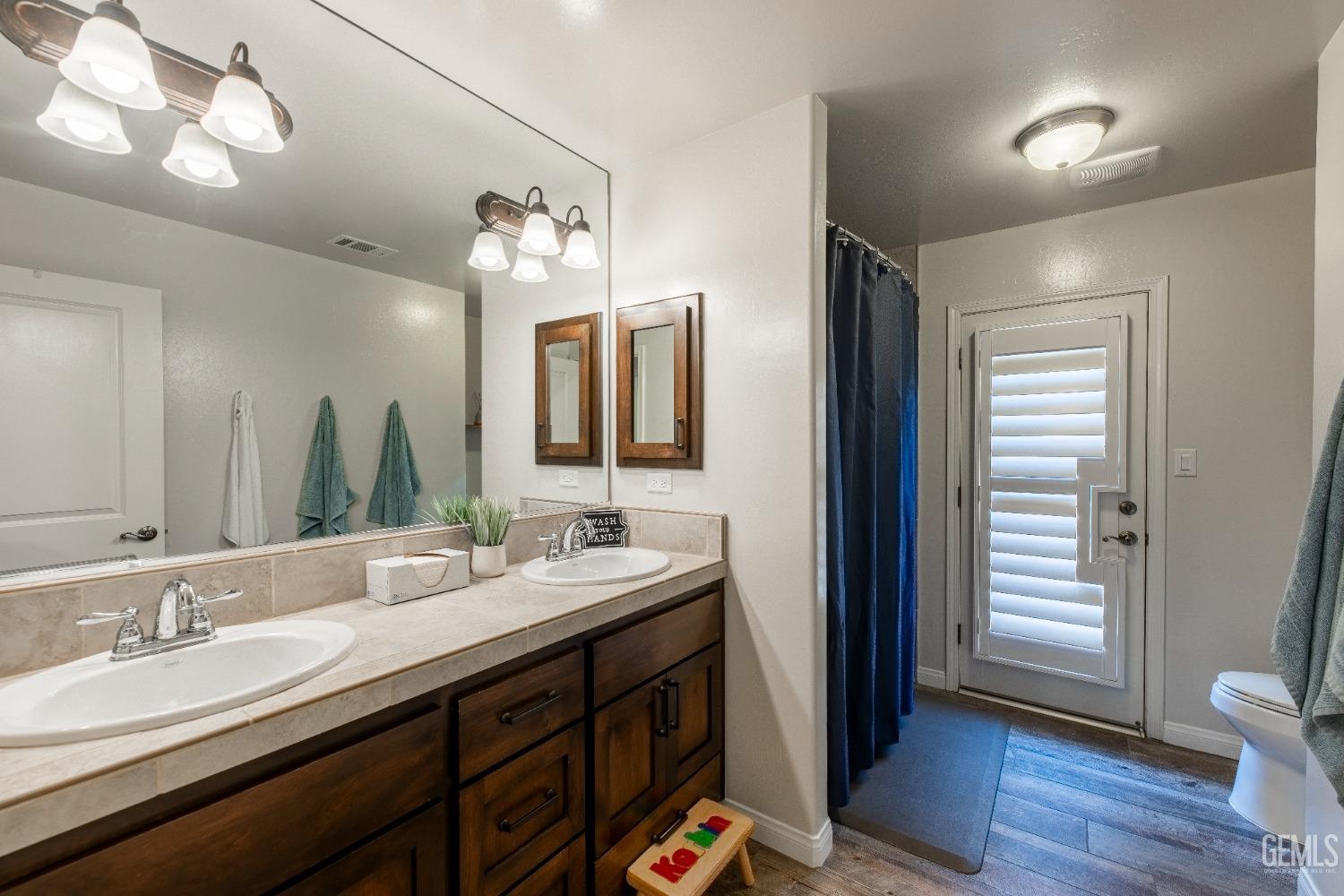 Undisclosed Address Bakersfield, CA 93312 - Photo 22 of 43 a bathroom with a double vanity sink and a mirror