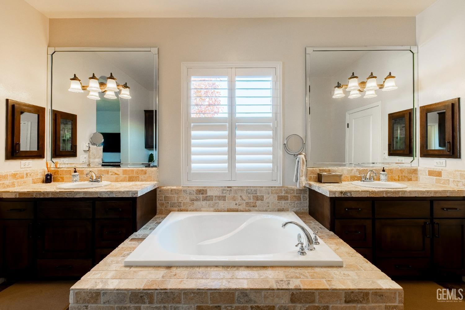 Undisclosed Address Bakersfield, CA 93312 - Photo 30 of 43 a bathroom with a bathtub a double vanity sink and mirror