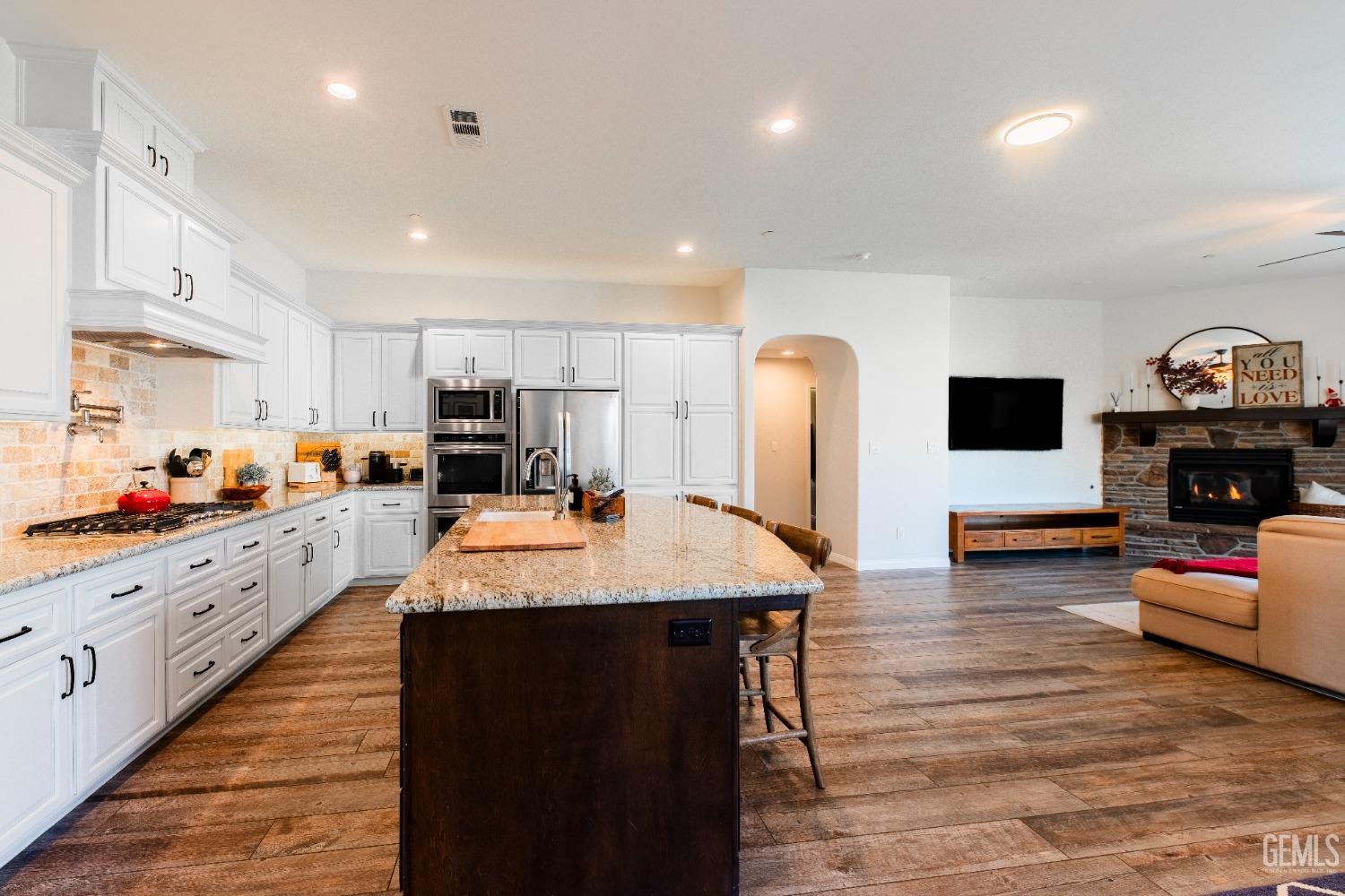 Undisclosed Address Bakersfield, CA 93312 - Photo 10 of 43 a large kitchen with stainless steel appliances kitchen island granite countertop a sink and a stove