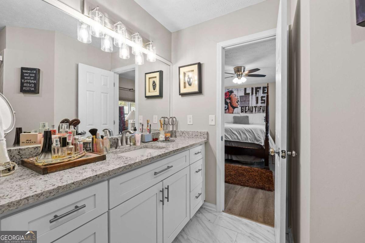 6324 Amberly Road Rex, GA 30273 - Photo 19 of 22 a en suite bathroom with a granite countertop sink and a mirror